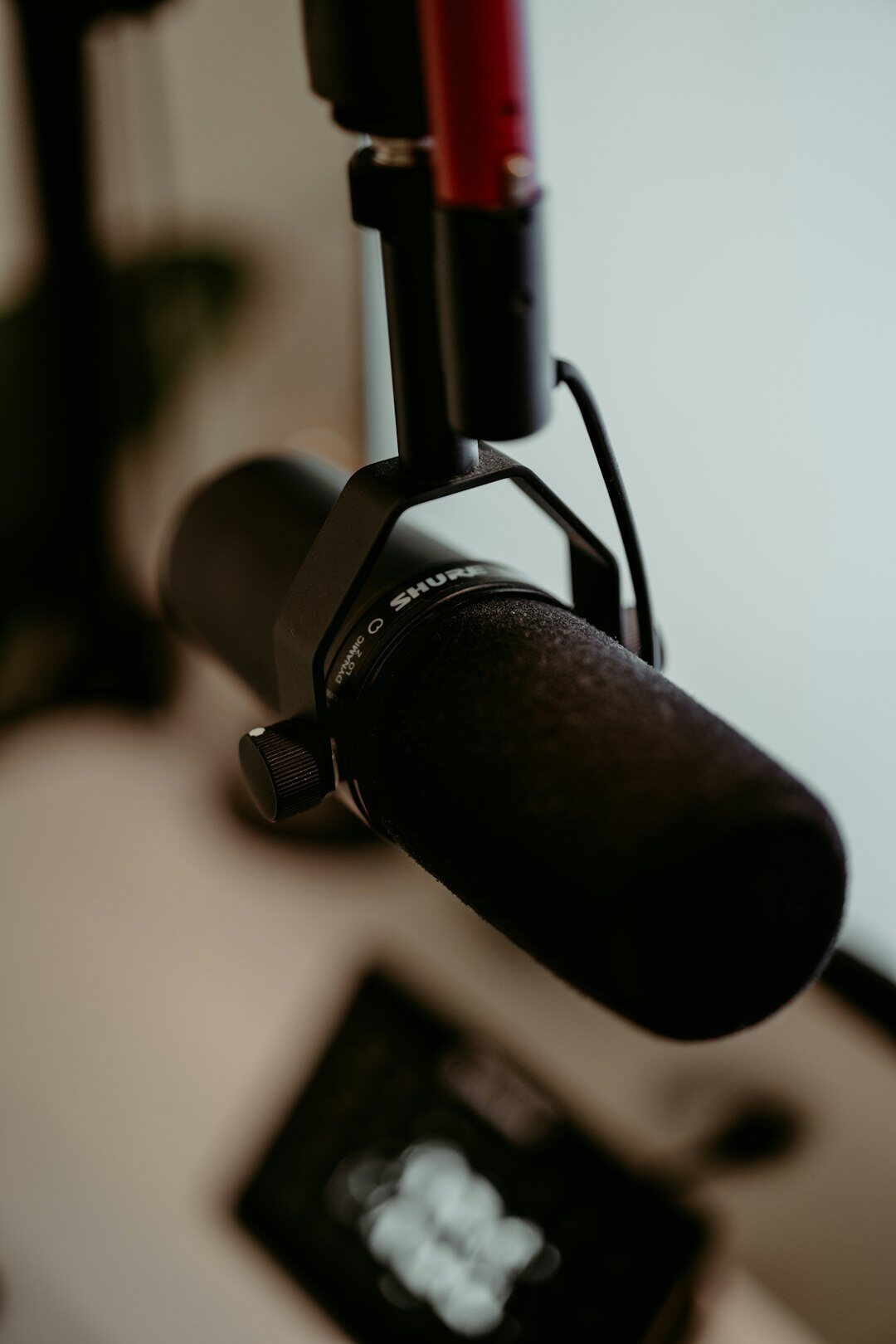 Two podcast hosts talking into microphones in a recording booth